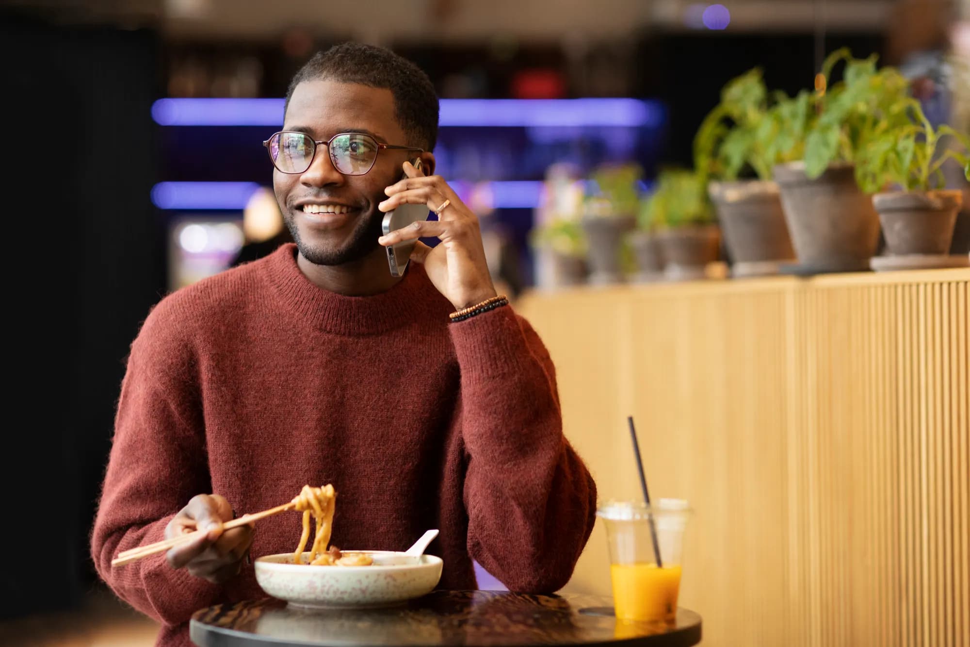 Un client consulte son téléphone à table, devant son plat, dans un restaurant.